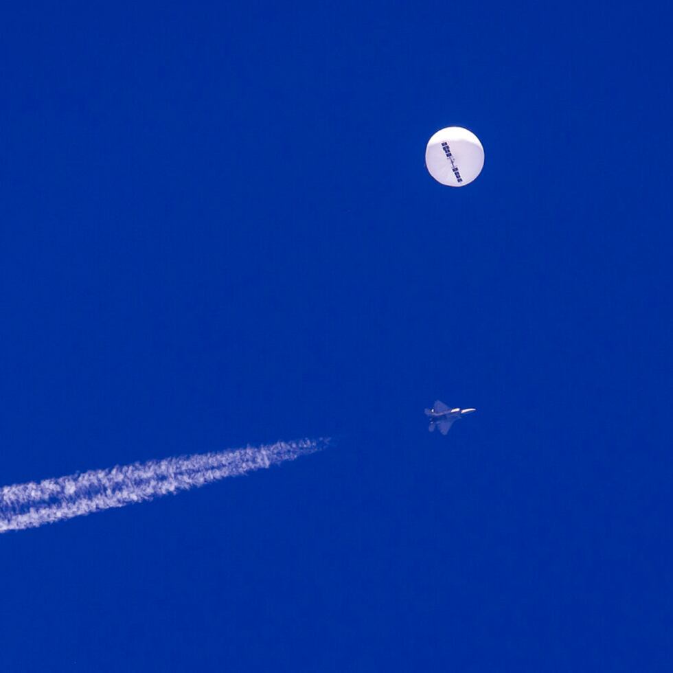 ARCHIVO - En esta foto provista por Chad Fish, un gran globo vuela sobre el Atlántico cerca de la costa de Carolina del Sur, y un avión de combate con su estela aparece por debajo, 4 de febrero de 2023. (Chad Fish via AP, File)