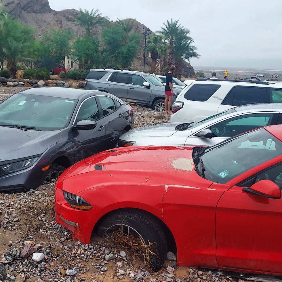 En esta foto proporcionada por el Servicio de Parques Nacionales de Estados Unidos, se ven automóviles atascados en el lodo debido a inundaciones repentinas el viernes 5 de agosto de 2022 en The Inn en el Parque Nacional del Valle de la Muerte, California.