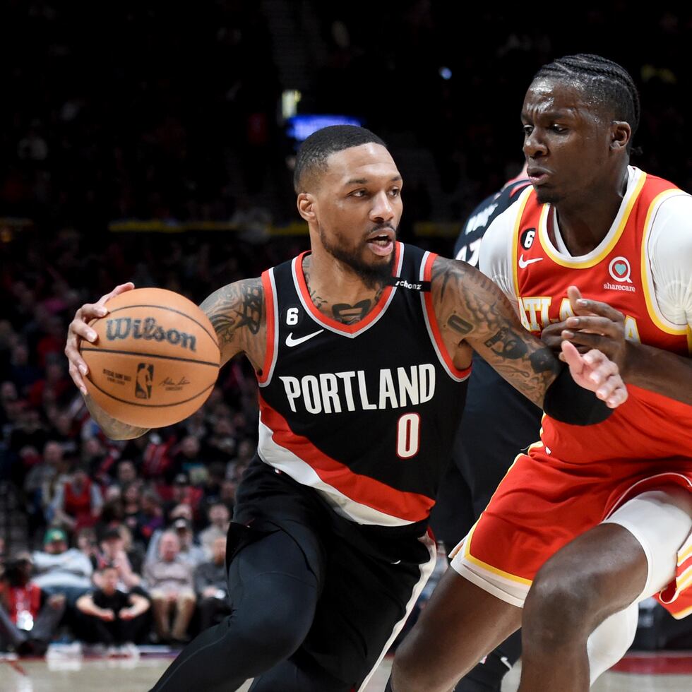 El jugador de los Trail Blazers de Portland Damian Lillard (izquierda) busca jugada ante Clint Capela, de los Hawks de Atlanta, en la segunda mitad del partido.