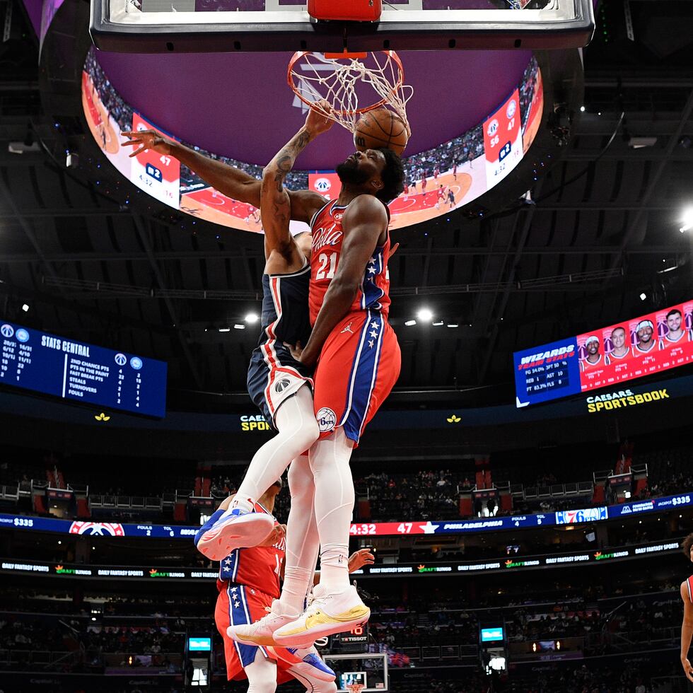 Kyle Kuzma, de Washington, donquea el balón de forma espectacular frente a la defensa de Joel Embiid.