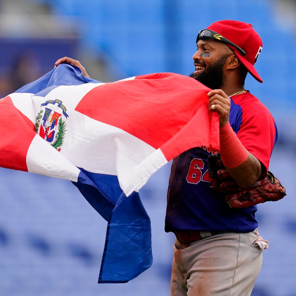El dominicano Emilio Bonifacio celebra con la bandera de su país tras la victoria 10-6 ante Corea del Sur por la medalla de bronce.