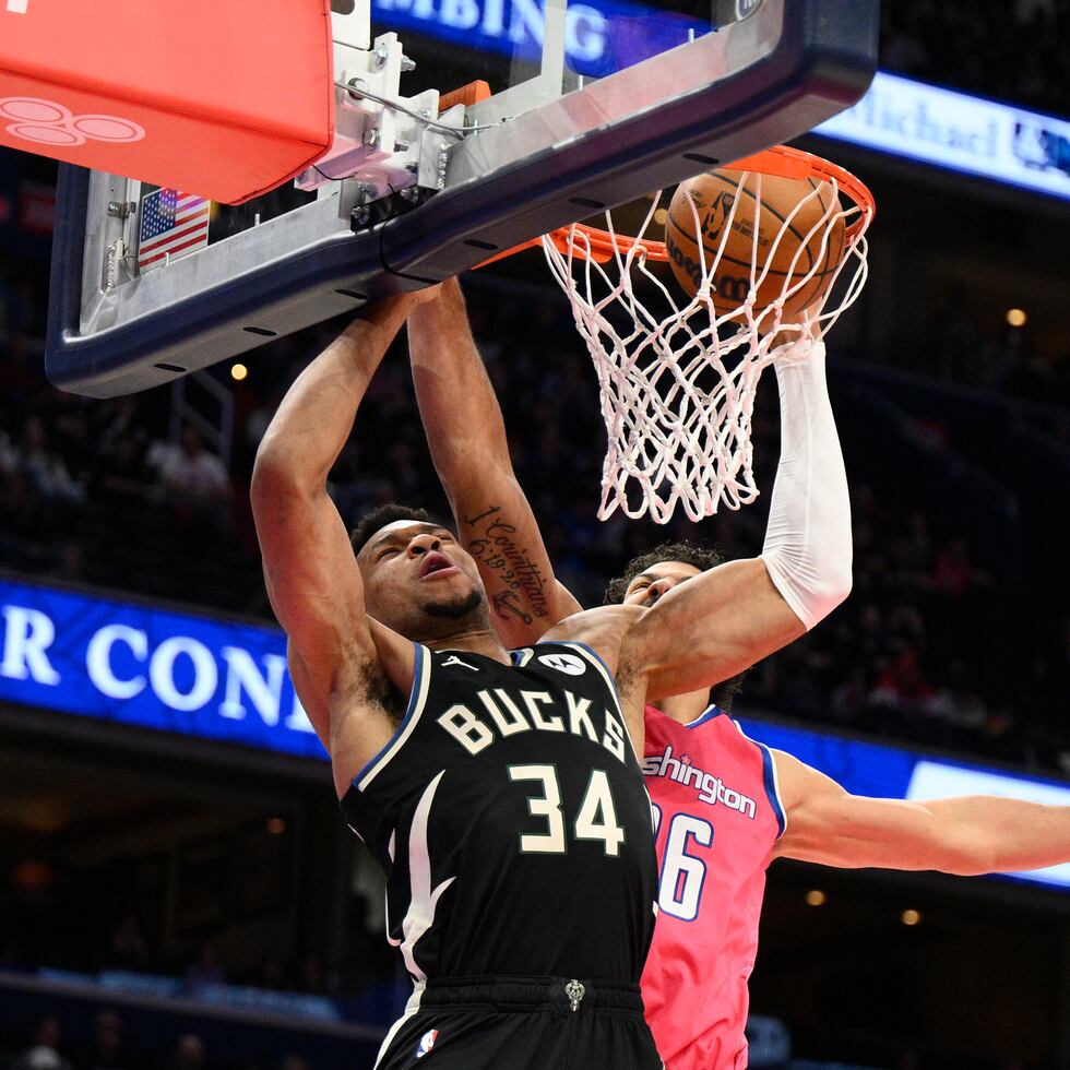 El alero de los Bucks de Milwaukee Giannis Antetokounmpo clava el balón frente al alero Anthony Gill, de los Wizards de Washington, en el encuentro del domingo.