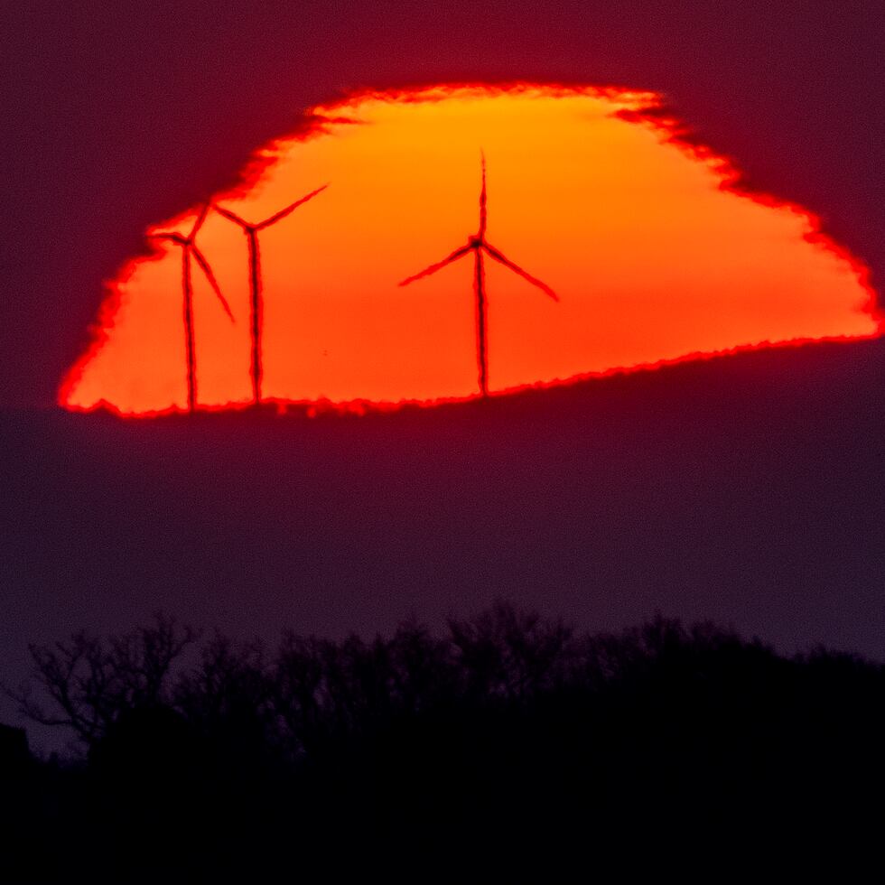 En esta imagen del 11 de marzo de 2022, se ven turbinas eólicas frente al Sol, que sale por el horizonte en Fráncfort, Alemania.