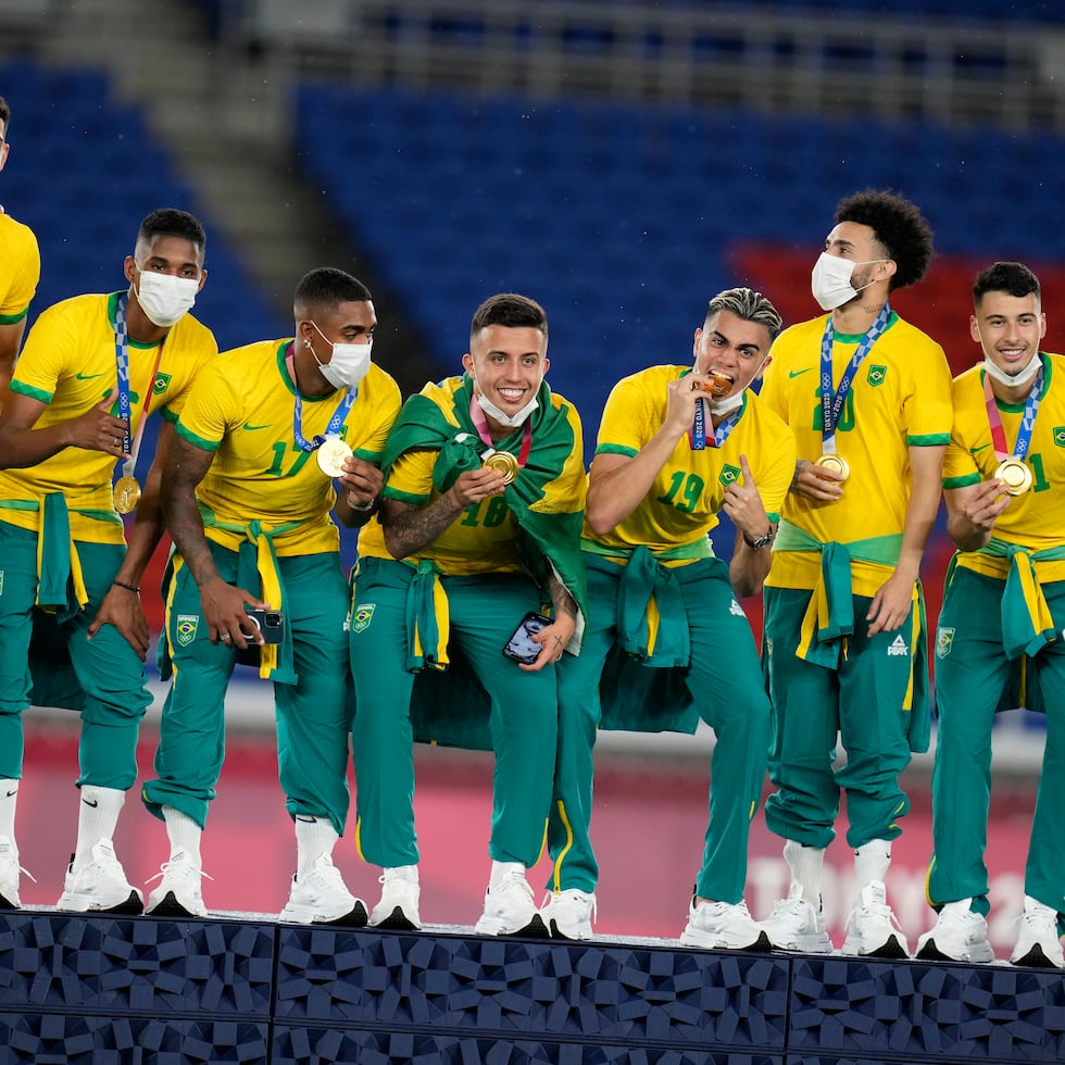 Integrantes del equipo de fútbol de Brasil celebran con la medalla de oro.