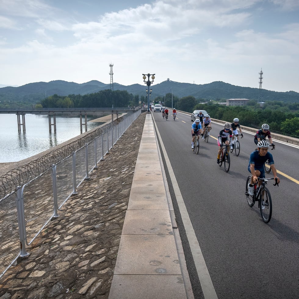 Un grupo de ciclistas pedalea junto al Embalse Miyun, en las afueras de Beijing, el 13 de julio del 2022. (AP Photo/Mark Schiefelbein)