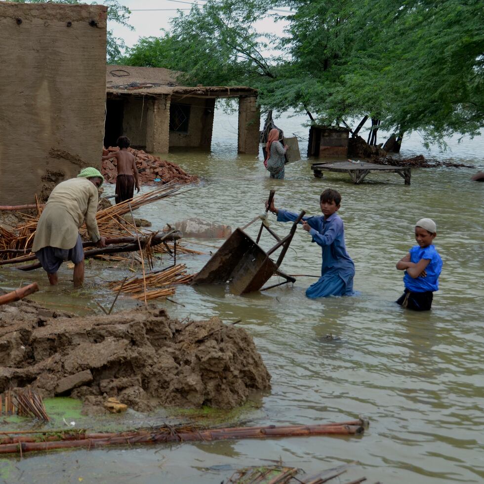 Una familia recupera artículos utilizables de su casa afectada por las inundaciones en Jaffarabad, un distrito de la provincia de Baluchistán, en el suroeste de Pakistán.