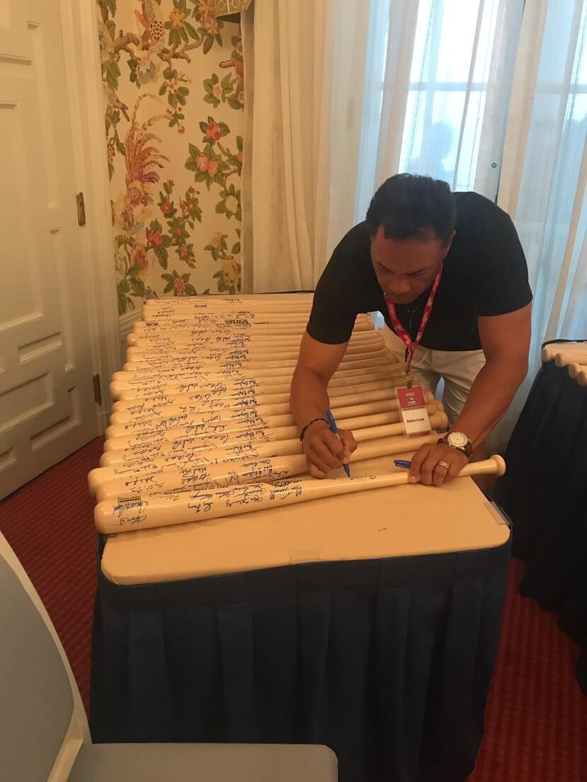 Roberto Alomar firma bates durante una actividad en Coopertown.