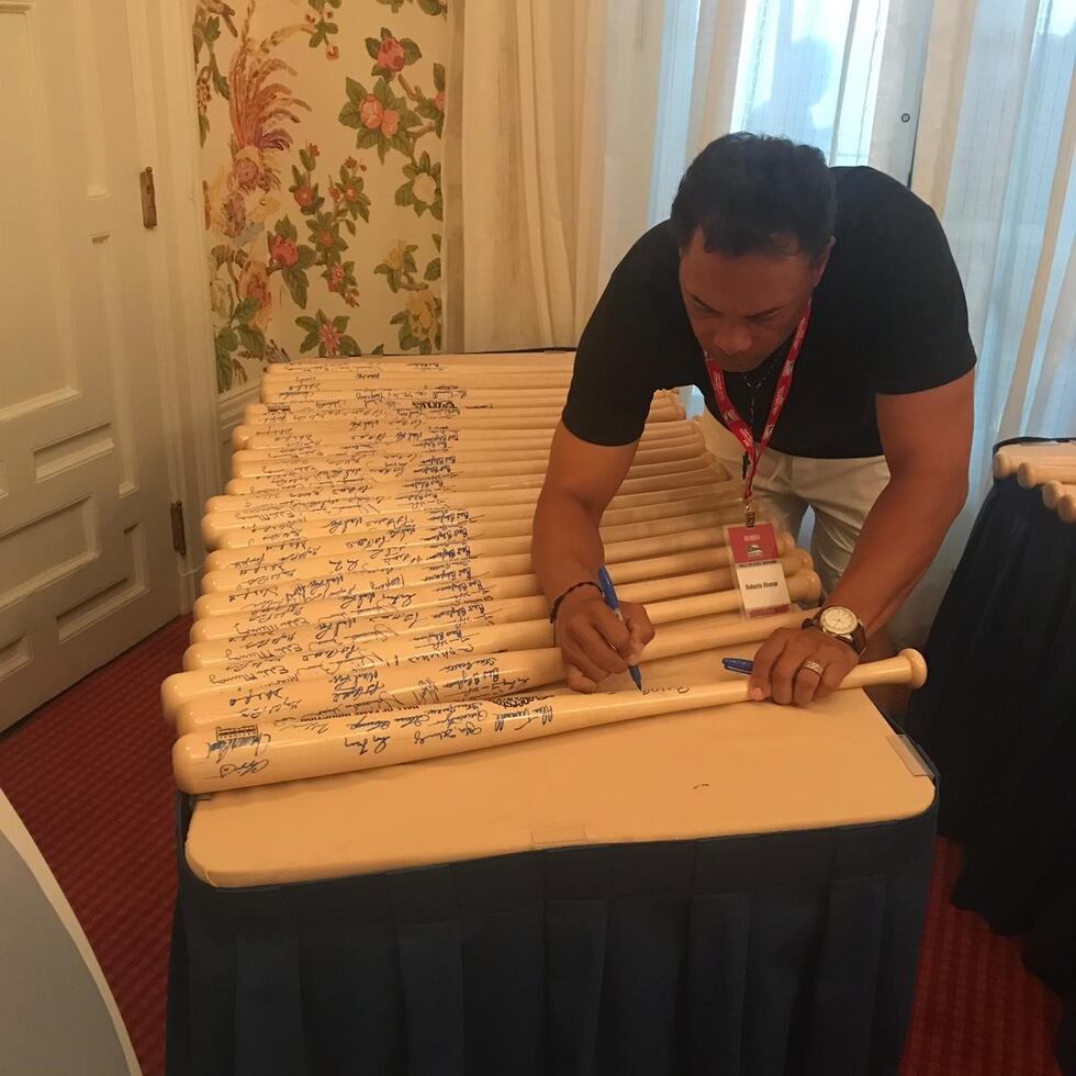 Roberto Alomar firma bates durante una actividad en Coopertown.