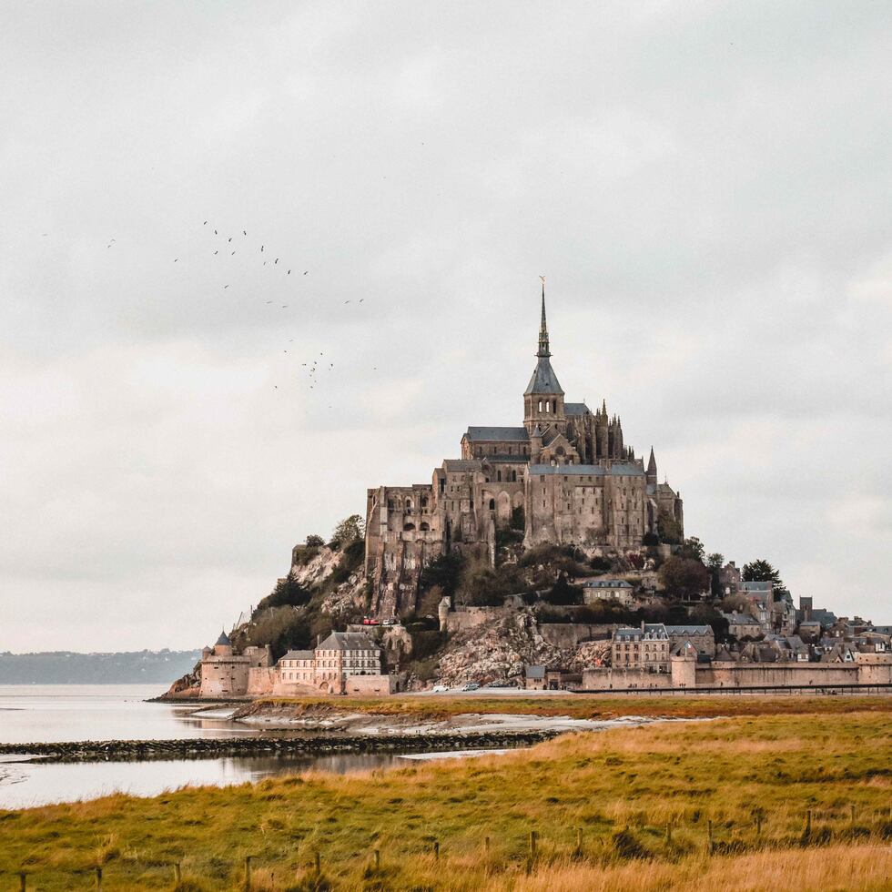 Visitar localidades como el Mont St. Michel, en Francia, ahora es más fácil y económico usando los sistema de transporte como los autobuses y los trenes. (Unplash)