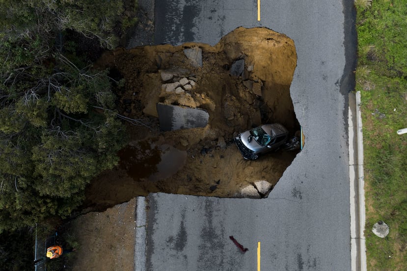 En esta imagen tomada con un drone se ve un vehículo dentro de un socavón, el martes 10 de enero de 2023, en Los Ángeles, California.