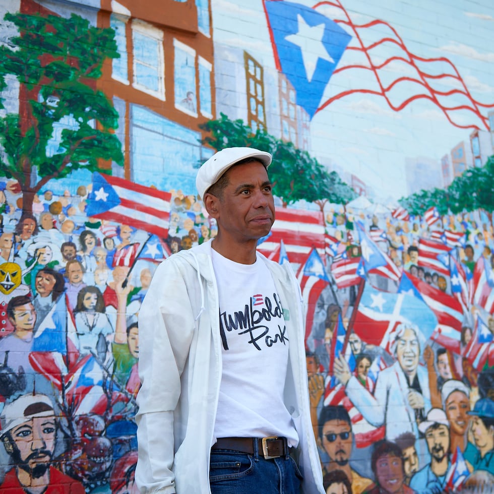 El Paseo Boricua destaca por su arte público, y específicamente sus murales. Hay sobre 80 murales en este pequeño microcosmos de Puerto Rico en la diáspora, como este: “Mar de Banderas” (2005), de Gamaliel Ramírez. En la foto, Eduardo Arocho, quien ofreció un tour de la zona.