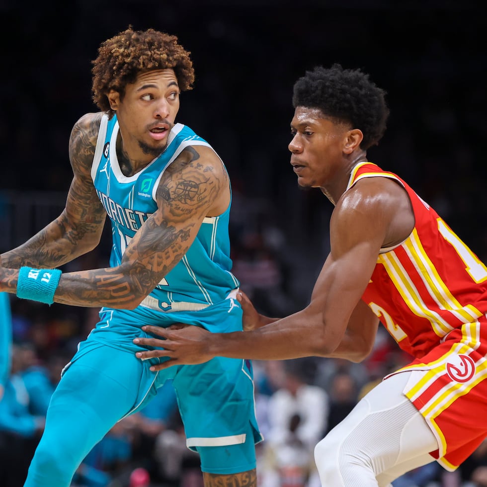 Kelly Oubre Jr. (izquierda), de los Hornets de Charlotte, enfrenta a De'Andre Hunter, de los Hawks de Atlanta, en el duelo de este domingo.