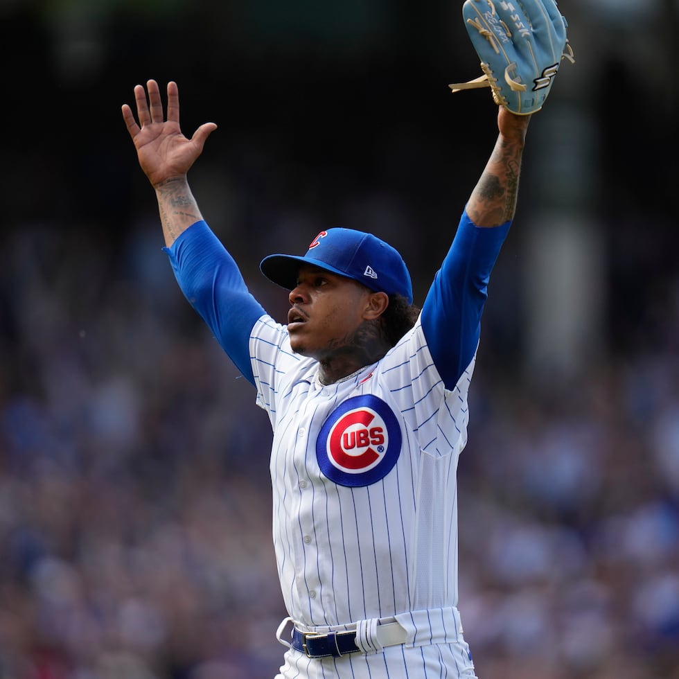 Marcus Stroman levanta los brazos en celebración tras conseguir la victoria.