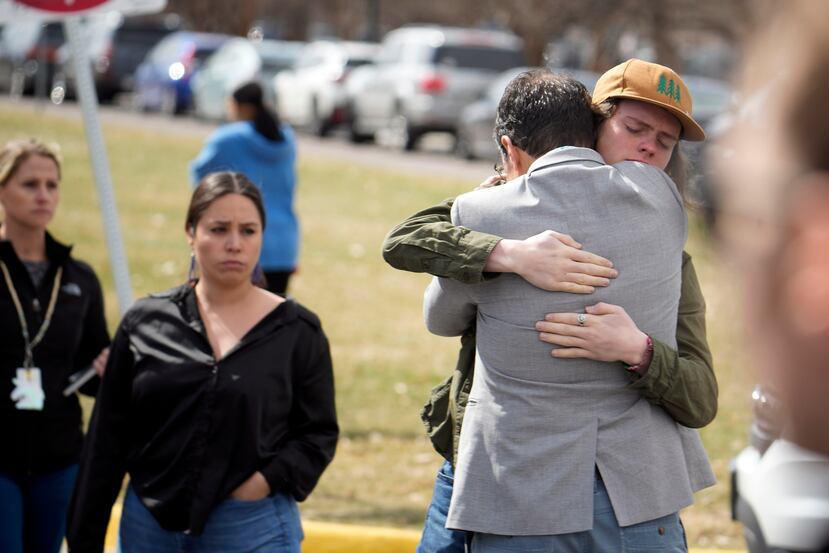 Un alumno, a la derecha, abraza a un padre al reunirse después de un tiroteo escolar en la escuela East High School, el miércoles.