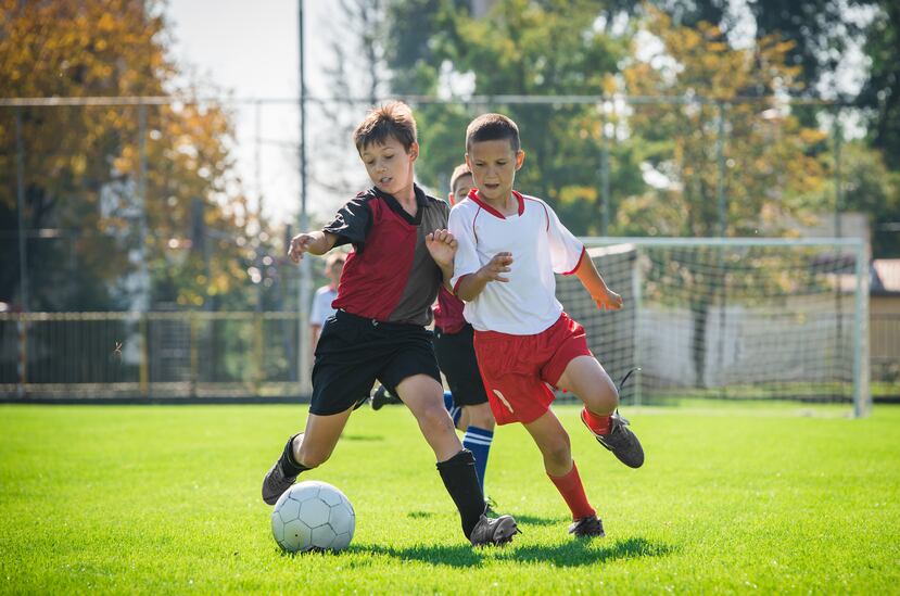 Niños jugando soccer durante un campamento de verano.