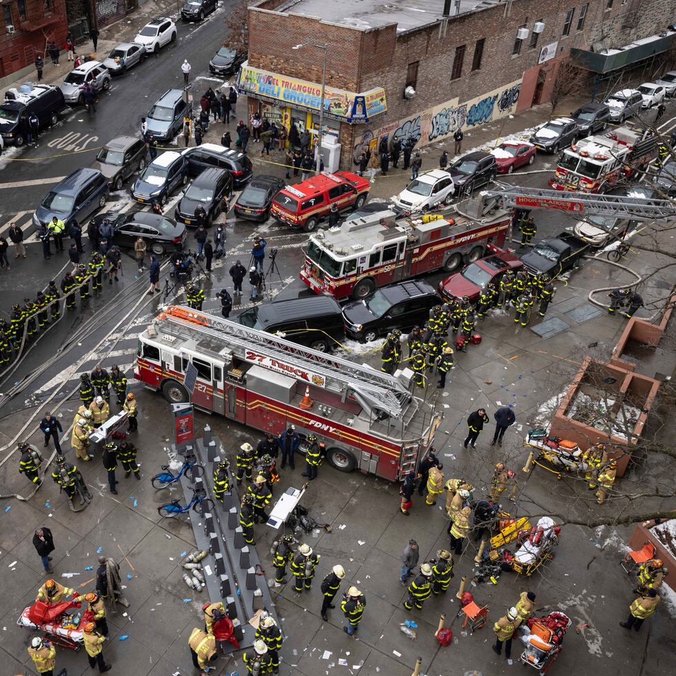 Firefighters work outside an apartment building after a fire in the Bronx, Sunday, Jan. 9, 2022, in New York. (AP Photo/Yuki Iwamura)