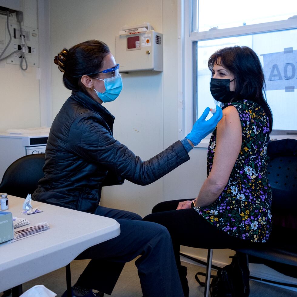 La enfermera Sarah Gonzalez le aplica a Claudia Zain su primera dosis de la vacuna contra el COVID-19 en una clínica de inoculación de New York Health and Hospitals en el distrito de Brooklyn, Nueva York.