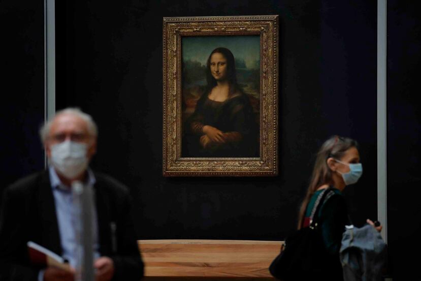 Periodistas pasan frente a la Mona Lisa de Leonardo da Vinci durante una visita al museo del Louvre previa a su reapertura el 6 de julio en París, el martes 23 de junio de 2020. (AP/Christophe Ena)