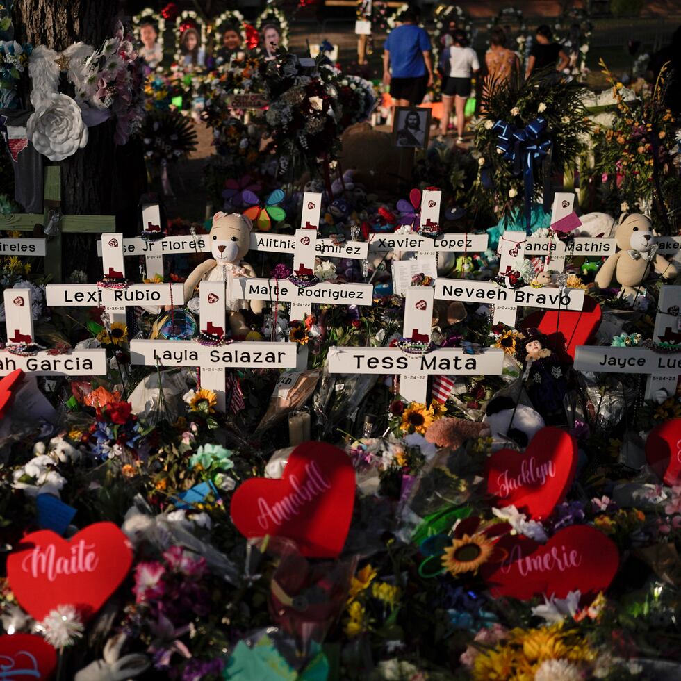 Flores se apilan alrededor de las cruces con los nombres de las víctimas asesinadas en el tiroteo en una escuela de Uvalde, Texas.