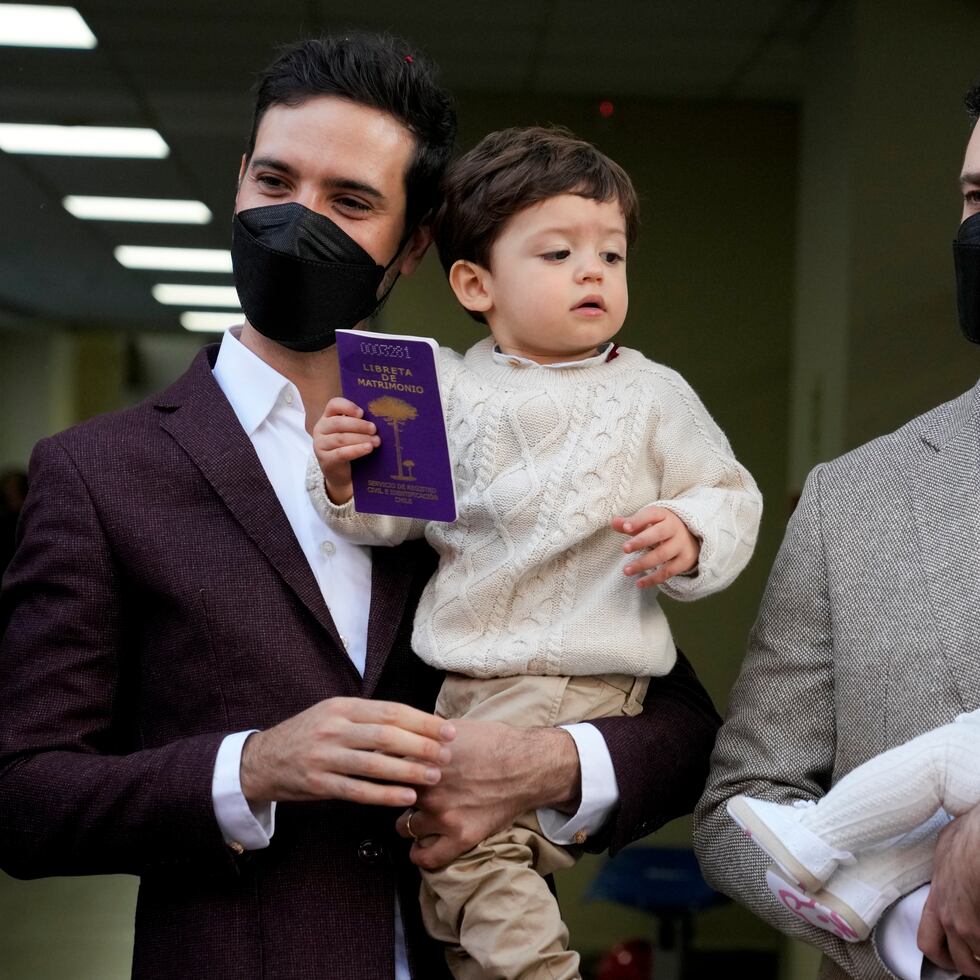 Javier Silva, con su hijo Clemente, y Jaime Nazar, con su hija Lola María, posan para una foto después de casarse en Santiago, Chile.