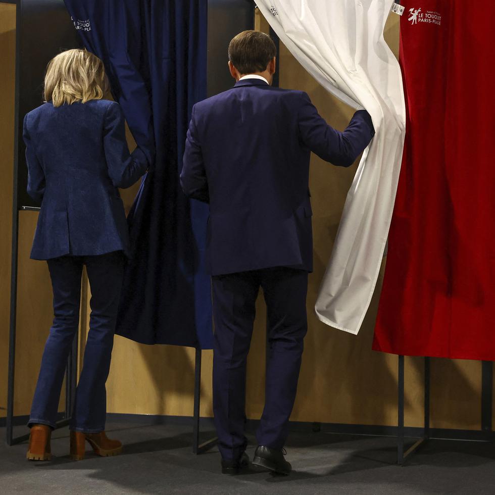 El presidente francés Emmanuel Macron y su esposa Brigitte Macron entran en una cabina de votación durante las elecciones europeas, el domingo 9 de junio de 2024 en Le Touquet-Paris-Plage, al norte de Francia. (Hannah McKay/Pool vía AP)