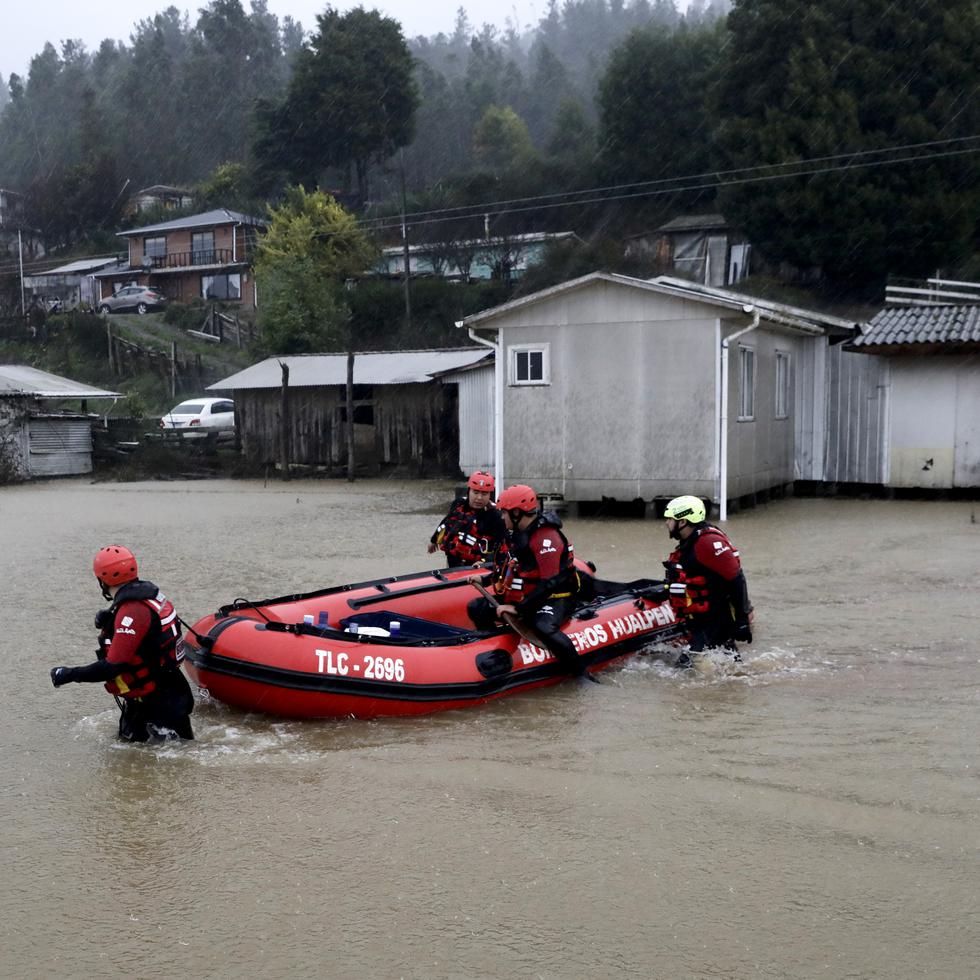 Rescatistas empujan un bote inflable en el desbordado río Pichilo después de que las tormentas azotaran el área en la provincia de Arauco, Chile, el jueves 13 de junio de 2024.