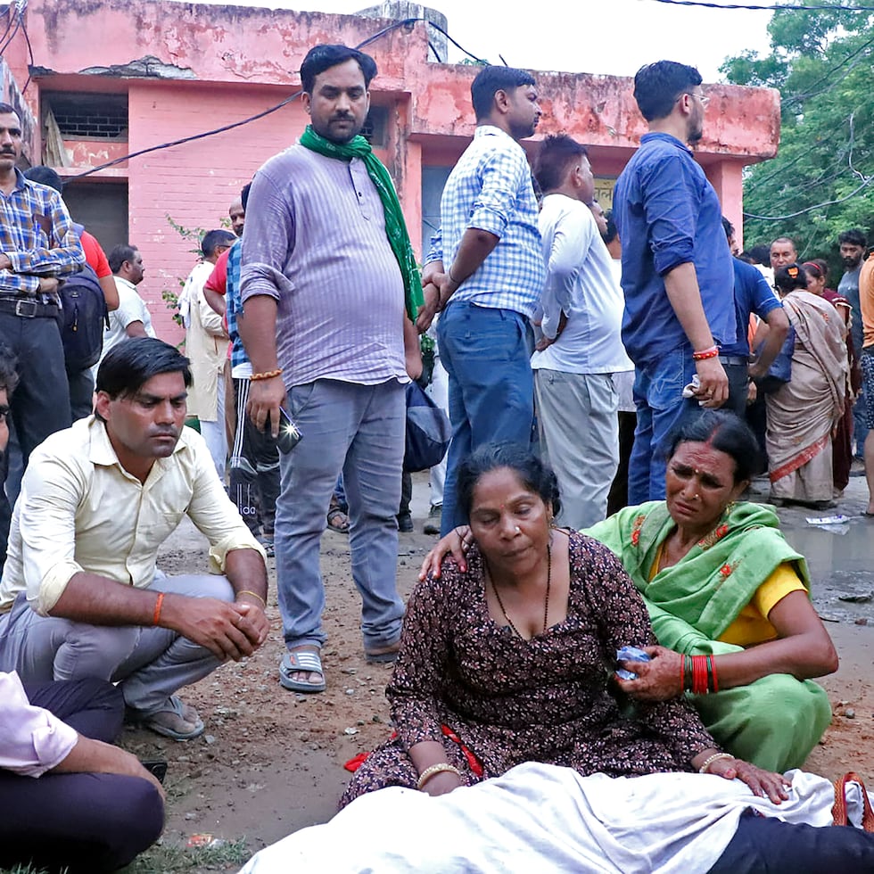 Mujeres lloran junto al cuerpo de un familiar afuera del hospital Sikandrarao en el distrito de Hathras