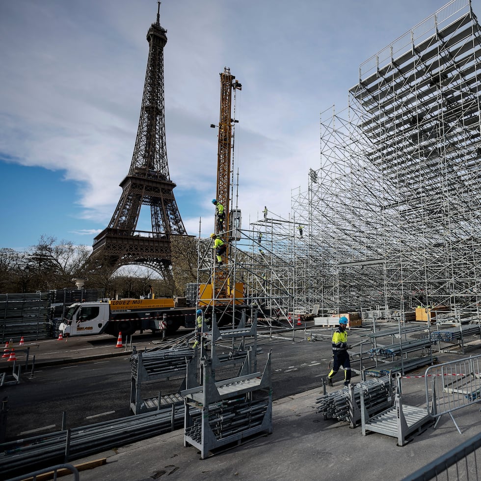 Trabajadores construyen gradas para los venideros Juegos Olímpicos en el Campo de Marte, justo al lado de la Torre Eiffel, en París.