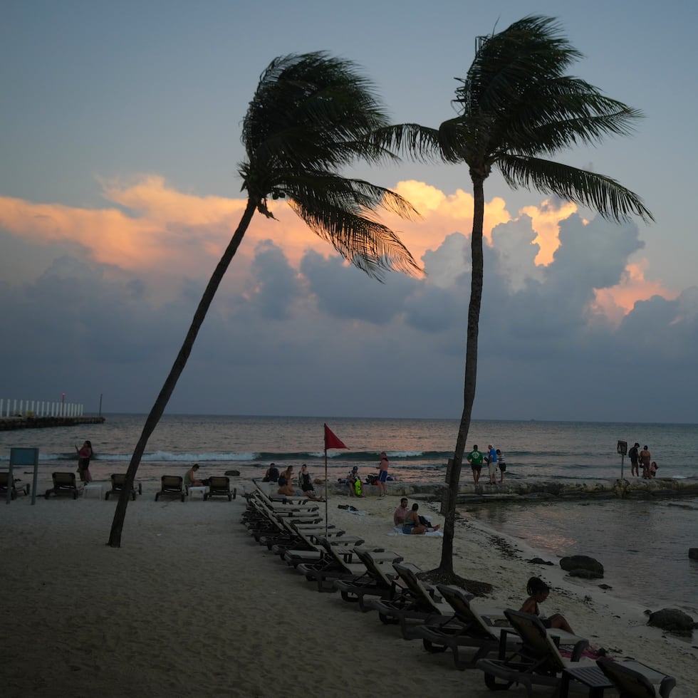 Gente en la playa mientras se pone el sol antes de la llegada del huracán Beryl en Playa del Carmen, México, este miércoles. La Armada mexicana patrullaba zonas como Tulum, explicando a turistas en inglés y en español que se preparasen para la llegada de la tormenta.