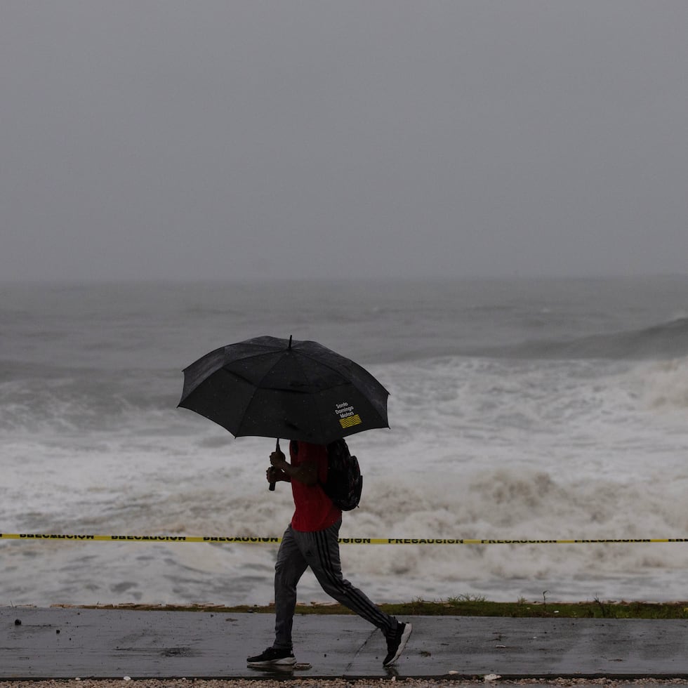 Un hombre camina frente al fuerte oleaje durante el paso del huracán Beryl, este martes en el malecón de Santo Domingo