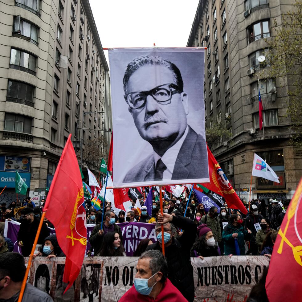 Un manifestante sostiene una fotografía del presidente chileno finado Salvador Allende durante las protestas por el 48vo aniversario del golpe militar de 1973 y su muerte subsecuente, en Santiago, Chile, el sábado 11 de septiembre de 2021. (AP Foto/Esteban Félix)