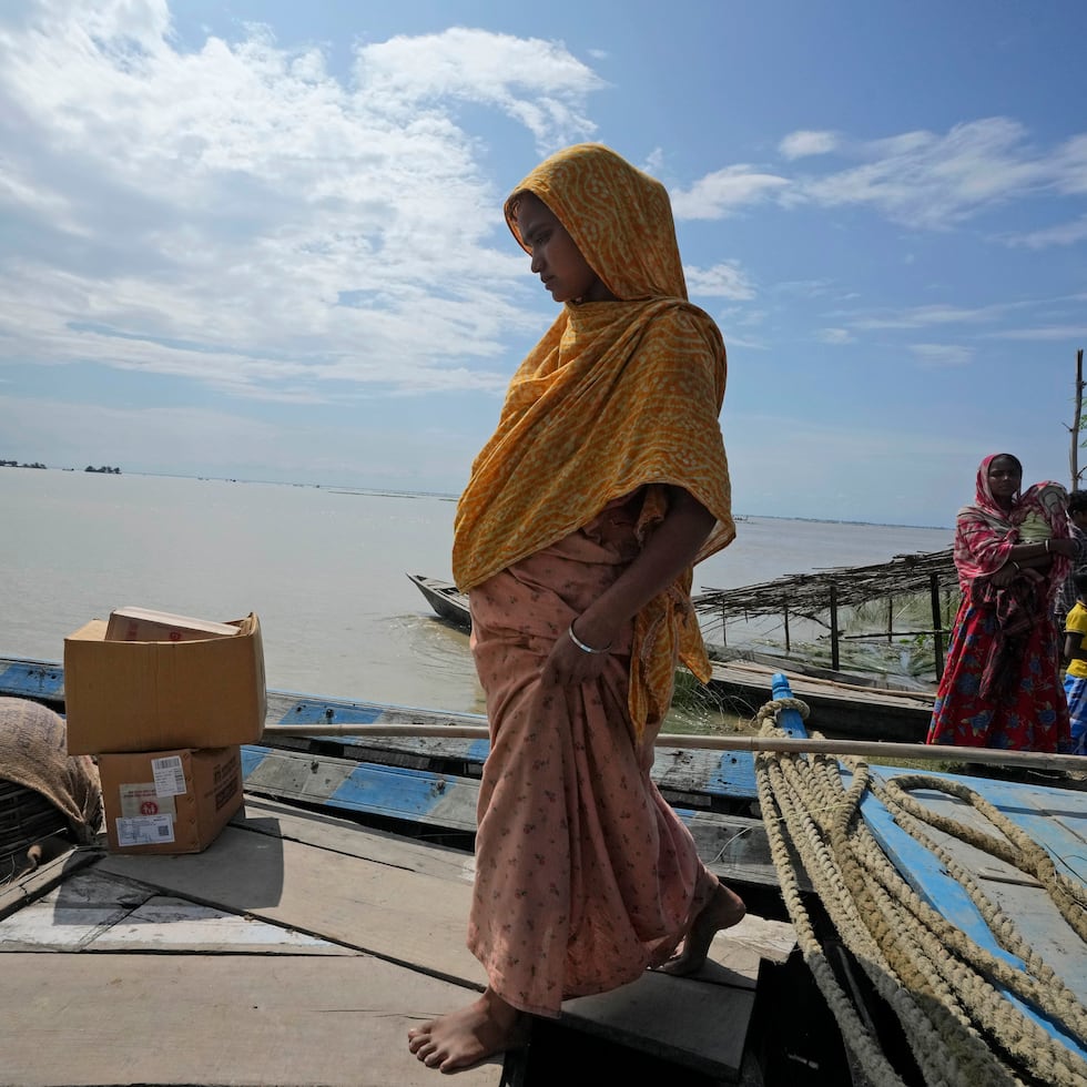 Jahanara Khatoon, de 25 años, sube a un barco para ir a un centro médico en Sandoh Khaiti Char, en el estado nororiental indio de Assam, el miércoles.