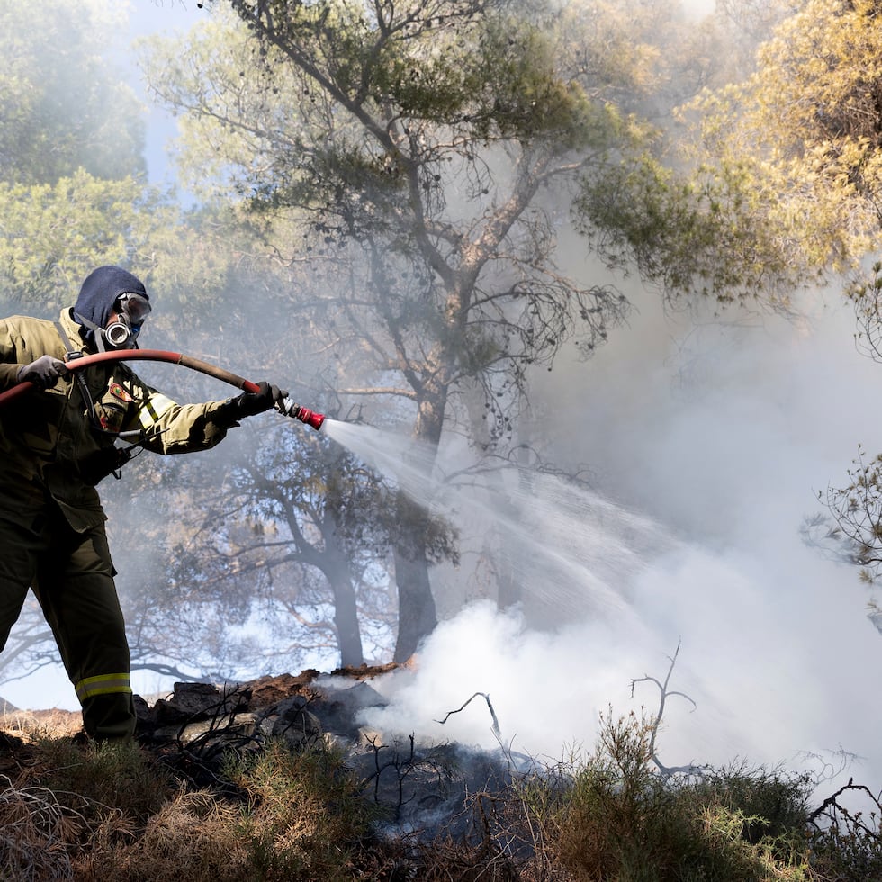 Un bombero intenta sofocar las llamas en el área de Keratea, al sureste de Atenas, Grecia.