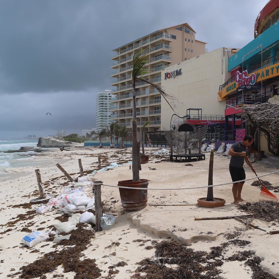 Comerciantes limpiando sus negocios después del paso del huracán Beryl por las principales playas en el balneario de Cancún, en Quintana Roo, México. Se espera que el fenómeno toque tierra nuevamente el domingo en algún punto en la frontera de México y Estados Unidos.