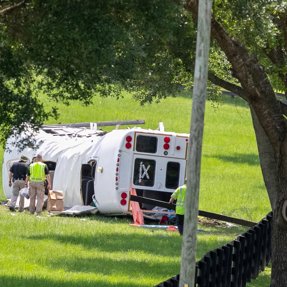 Policía y socorristas inspeccionan un autobús que se volcó tras chocar con una camioneta matando a ocho de 50 jornaleros que iban en el camión, en Ocala, Florida.