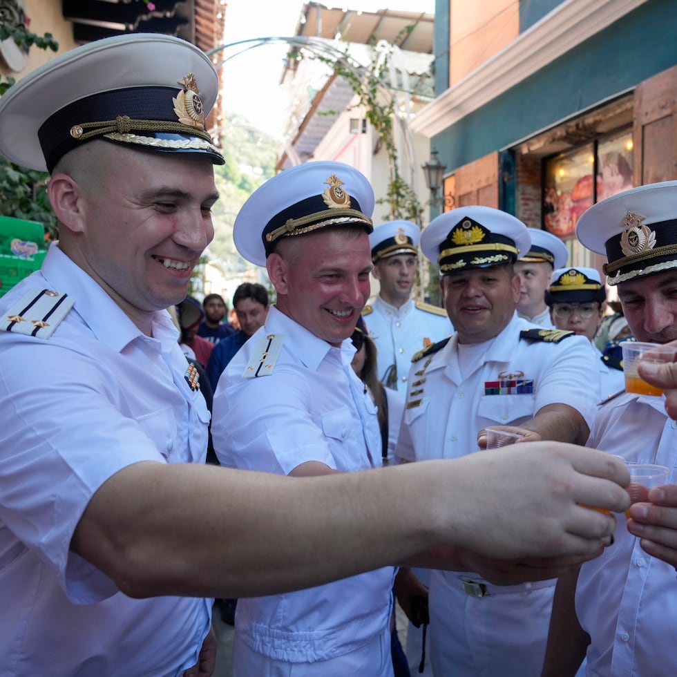 Miembros de tripulación rusos brindan con una bebida tradicional venezolana en una visita de bienvenida con autoridades en La Guaira, Venezuela, después de que la fragata Almirante Gorshkov y el buque petrolero Akademik Pashin de la Armada rusa atracaran en puerto, el martes 2 de julio.