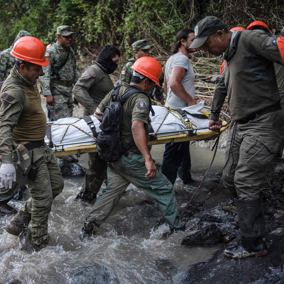 Rescatistas recuperan el cuerpo de un policía que falleció en un accidente vehicular mientras revisaba los daños causados por las lluvias, el martes 2 de julio, en Alto Lucero, Veracruz, México.